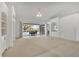 Spacious living room featuring carpeting, built-in shelving, and sliding glass doors leading to the pool area at 945 Chickadee Dr, Venice, FL 34285