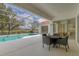 Screened-in lanai with table overlooks the pool and landscaped grounds at 945 Chickadee Dr, Venice, FL 34285