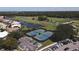 Aerial view of fenced tennis courts next to the golf course and parking area at 945 Chickadee Dr, Venice, FL 34285