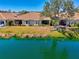 Inviting backyard with a serene lake view, lush landscaping, and a well-maintained lawn at 1022 Yosemite Dr, Englewood, FL 34223