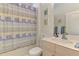 Bright bathroom featuring a seashell-themed shower curtain and charming floral artwork at 1022 Yosemite Dr, Englewood, FL 34223
