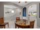 Bright dining room with a glass-top table, rattan chairs, tiled floors, and seamless access to the hallway and a modern kitchen at 1050 Jonah Dr, North Port, FL 34289