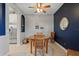 Cozy dining room features a round wooden table with rattan chairs, stylish decor, and seamless access to the adjacent kitchen at 1050 Jonah Dr, North Port, FL 34289
