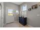 Inviting foyer with tiled flooring, a charming round window, a stylish cabinet, and natural light, creating a welcoming entrance at 1050 Jonah Dr, North Port, FL 34289