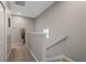 Upstairs hallway featuring carpet flooring, neutral walls, and white railings leading to bedrooms at 1050 Jonah Dr, North Port, FL 34289