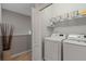 Well-equipped laundry room with white washer and dryer units, and ample shelving with stylish baskets at 1050 Jonah Dr, North Port, FL 34289