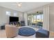 Cozy living room with tile flooring, neutral walls, a ceiling fan, and sliding glass doors leading to lanai at 1050 Jonah Dr, North Port, FL 34289