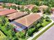 Aerial view features a home with screened patio, landscaped yard in neighborhood with lush greenery, enhancing curb appeal at 1088 Bluffwood Dr, Nokomis, FL 34275