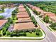 Aerial view showcases a home with a screened patio, landscaped yard, and proximity to a serene lake in a neighborhood at 1088 Bluffwood Dr, Nokomis, FL 34275