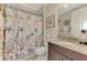 Nautical-themed bathroom with granite counters, and a shower/tub combo with a decorative shower curtain at 1088 Bluffwood Dr, Nokomis, FL 34275
