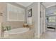 A relaxing soaking tub encased in tile, with a bright window offering natural light at 1088 Bluffwood Dr, Nokomis, FL 34275