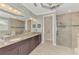 A luxurious bathroom with granite counters, double sinks, and a glass-enclosed shower at 1088 Bluffwood Dr, Nokomis, FL 34275