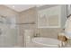 Spa-like bathroom featuring a glass shower, soaking tub, and a bright window with plantation shutters at 1088 Bluffwood Dr, Nokomis, FL 34275