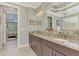 Bathroom vanity featuring granite counters, dark wood cabinets and large mirror with decorative lighting at 1088 Bluffwood Dr, Nokomis, FL 34275