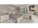 Cozy bedroom with a plush rug, white furniture, and a bright window with plantation shutters at 1088 Bluffwood Dr, Nokomis, FL 34275