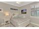 Bright bedroom with a ceiling fan and white furniture, featuring a window with plantation shutters at 1088 Bluffwood Dr, Nokomis, FL 34275