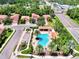 Overhead shot of community pool, showcasing lounge areas, palm trees, and parking at 1088 Bluffwood Dr, Nokomis, FL 34275