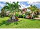 Well-manicured front yard with lush landscaping and mature palm trees at 1088 Bluffwood Dr, Nokomis, FL 34275