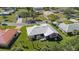 Aerial view of pink home featuring a screened-in patio and white shingle roof surrounded by landscaping at 111 2Nd St, Nokomis, FL 34275