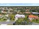 An aerial view shows this pink home situated in a lush green neighborhood under a sunny sky at 111 2Nd St, Nokomis, FL 34275