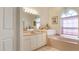 Bright bathroom featuring a bathtub and tiled flooring with a chandelier and ample natural light at 111 2Nd St, Nokomis, FL 34275