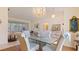 Dining room showcasing a glass table with covered chairs, chandelier and elegant decor accents at 111 2Nd St, Nokomis, FL 34275