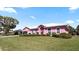 A delightful pink house featuring arched windows and a beautiful lawn on a sunny day at 111 2Nd St, Nokomis, FL 34275