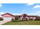 Charming pink home with a well-manicured lawn and white trim against a blue sky at 111 2Nd St, Nokomis, FL 34275