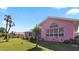 Charming pink single-story home featuring well-maintained landscaping and a sunny front yard at 111 2Nd St, Nokomis, FL 34275