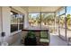 Relaxing hot tub in a screened-in patio area with a chair and small end table with plants at 111 2Nd St, Nokomis, FL 34275