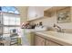 Bright laundry room featuring a washing machine, sink with counter, and overhead cabinets for convenient storage at 111 2Nd St, Nokomis, FL 34275