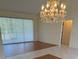 Bright living room with a chandelier, wood flooring and a large window with blinds at 111 2Nd St, Nokomis, FL 34275
