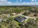 Aerial view of a modern, white single-story home surrounded by lush greenery and a paved road at 1131 Chalmer Ter, Port Charlotte, FL 33953