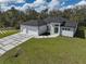 Aerial view of a home featuring a three-car garage, modern exterior, and pristine landscaping at 1131 Chalmer Ter, Port Charlotte, FL 33953