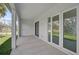 Covered porch with white pillars, sliding glass door, and double French doors with a view of the front yard at 1131 Chalmer Ter, Port Charlotte, FL 33953