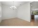 A dining room with tile floors, a chandelier, and a view into the kitchen at 11415 Fort Lauderdale Pl, Venice, FL 34293