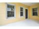 Welcoming yellow home with a quaint front porch and large windows offering great natural light at 11415 Fort Lauderdale Pl, Venice, FL 34293