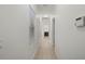 Hallway with neutral tones and tile flooring leads to additional rooms and features a window at 11415 Fort Lauderdale Pl, Venice, FL 34293