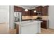 A kitchen island with stainless steel appliances, a granite countertop, and dark wood cabinets at 11415 Fort Lauderdale Pl, Venice, FL 34293
