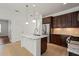 Kitchen featuring stainless steel appliances, granite countertops, dark wood cabinets, and an island at 11415 Fort Lauderdale Pl, Venice, FL 34293