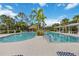 Resort-style pool area with palm trees, cabana, and blue skies at 11415 Fort Lauderdale Pl, Venice, FL 34293