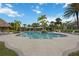 Community pool surrounded by palm trees and comfortable seating at 11415 Fort Lauderdale Pl, Venice, FL 34293