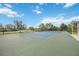 Community tennis court, enclosed by fencing and lush landscaping at 11415 Fort Lauderdale Pl, Venice, FL 34293