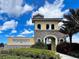 Community entrance featuring stone and stucco architecture with lush landscaping under a sunny sky at 11558 Renaissance Blvd, Venice, FL 34293