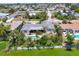 Aerial view features a home with pool and screened patio, complemented by lush landscaping near a serene canal at 1220 Lakeside Dr, Venice, FL 34293