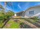 The backyard features a screened-in lanai, lush landscaping, and well-maintained lawn at 1220 Lakeside Dr, Venice, FL 34293