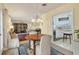 Open dining room featuring a chandelier and views into both the living room and kitchen at 1220 Lakeside Dr, Venice, FL 34293