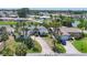 Aerial view of single-story home, palm trees, lawn, and private drive in tropical neighborhood at 1220 Lakeside Dr, Venice, FL 34293