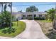 Charming single story home with a curved driveway and lush tropical landscaping in a beautiful setting at 1220 Lakeside Dr, Venice, FL 34293