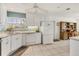 Bright kitchen features white cabinets, stainless appliances, tile floors, and ample counter space at 1220 Lakeside Dr, Venice, FL 34293
